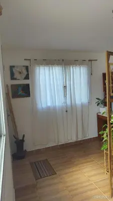 a room with a window with white curtains and a wooden floor at Makipura in Cordoba