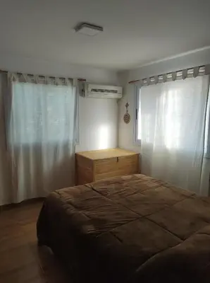 a bedroom with a bed and a dresser and a window at Makipura in Cordoba