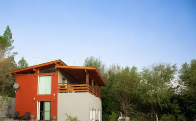 a house with a red and white at Chalets de la paix in Santa Rosa de Calamuchita