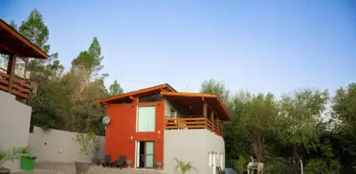a house with a red and white at Chalets de la paix in Santa Rosa de Calamuchita