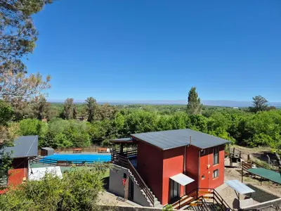 an aerial view of a red building with a pool at Chalets de la paix in Santa Rosa de Calamuchita