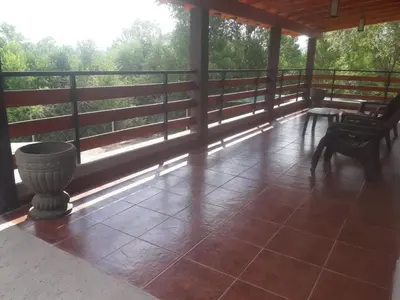 a screened in porch with chairs and a table at Chalets de la paix in Santa Rosa de Calamuchita