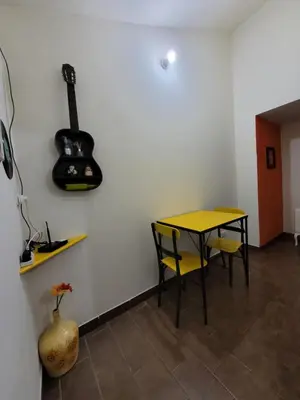 a room with a table and a guitar on the wall at Doña Vanina in Villa Larca