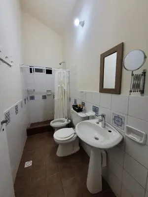 a bathroom with a sink and a toilet and a mirror at Doña Vanina in Villa Larca
