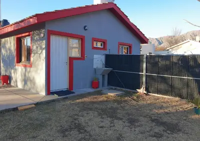 a small house with a red door and a fence at Doña Vanina in Villa Larca