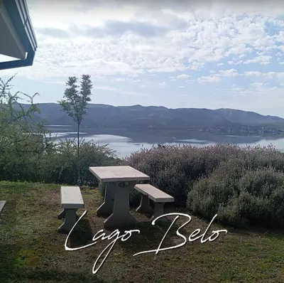 a picnic table with a view of a lake at Lago Belo in Cordoba
