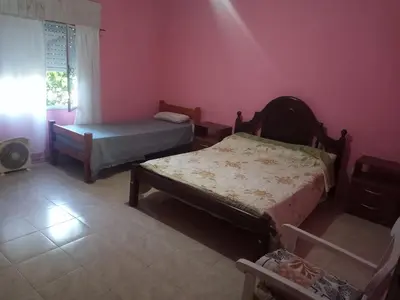 a bedroom with two beds in a room with pink walls at Casa en Las Tapias cerca de Villa de Las Rosas in San Javier