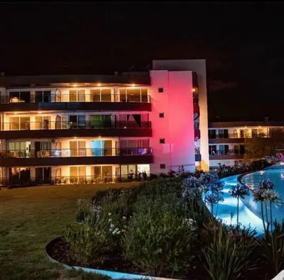 a large building with a pool in front of it at night at Departamento con vista al lago en Veneto Village in Villa Parque Siquiman