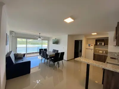a living room with a table and chairs and a kitchen at Departamento con vista al lago en Veneto Village in Villa Parque Siquiman