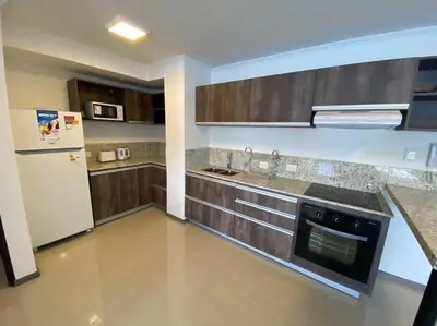 a kitchen with wooden cabinets and a white refrigerator at Departamento con vista al lago en Veneto Village in Villa Parque Siquiman