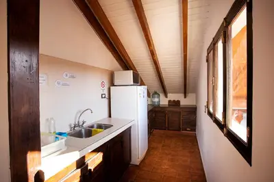 a kitchen with a white refrigerator and a sink at Cucu Haus Hostel in La Cumbrecita