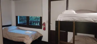 a bedroom with two bunk beds and a window at Cucu Haus Hostel in La Cumbrecita