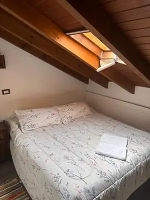 a bed in a small room with a skylight at Cucu Haus Hostel in La Cumbrecita