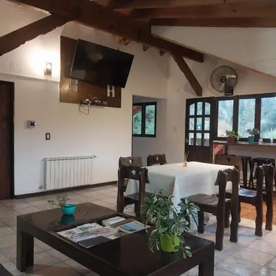 a living room with a white table and chairs at Cucu Haus Hostel in La Cumbrecita