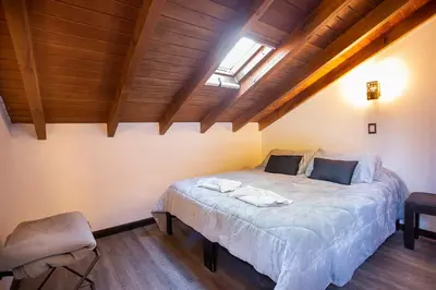 a bedroom with a bed in a room with wooden ceilings at Cucu Haus Hostel in La Cumbrecita
