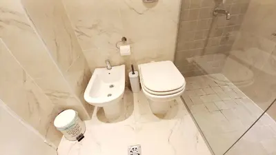 a white bathroom with a toilet and a shower at Dpto Temporario Córdoba, ubicación ideal in Cordoba