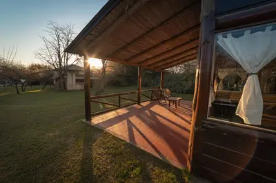 a covered porch of a house with a bench on it at Cabañas Cuatro Horizontes in Villa General Belgrano