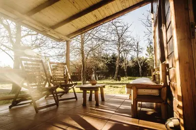 a patio with two chairs and a table on a porch at Cabañas Cuatro Horizontes in Villa General Belgrano