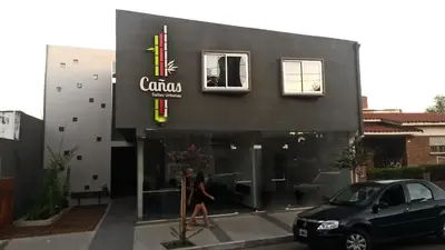 a woman walking in front of a building at Cañas Suites Urbanas in Mina Clavero