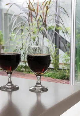 two glasses of red wine sitting on a table at Cañas Suites Urbanas in Mina Clavero