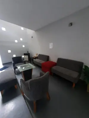 a waiting room with couches and a table and chairs at Cañas Suites Urbanas in Mina Clavero