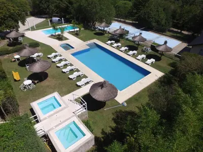 an overhead view of a swimming pool with chairs and umbrellas at Aldea de los Pajaros in Villa General Belgrano