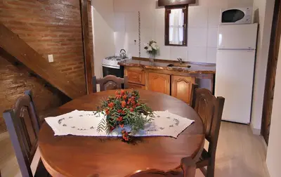 a kitchen with a wooden table with flowers on it at Aldea de los Pajaros in Villa General Belgrano