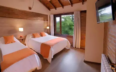 a hotel room with two beds and a window at Aldea de los Pajaros in Villa General Belgrano