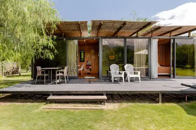 a patio with chairs and a table in a yard at Cabañas con jacuzzi privado y vistas al cerro Champaquí in San Javier