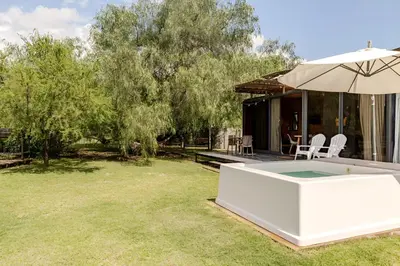 a backyard with a hot tub and an umbrella at Cabañas con jacuzzi privado y vistas al cerro Champaquí in San Javier