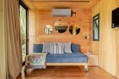 a bedroom with a blue bed in a tiny house at Cabañas con jacuzzi privado y vistas al cerro Champaquí in San Javier