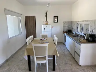a kitchen with a table and chairs and a refrigerator at Casa del Valle Merlo in Merlo