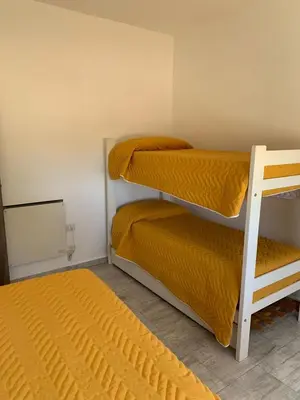 a small room with two bunk beds and a mirror at Casa del Valle Merlo in Merlo