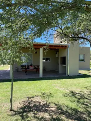 a house with a patio and a tree at Casa del Valle Merlo in Merlo