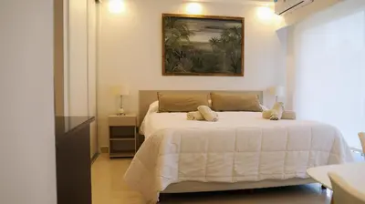 a bedroom with a white bed with a painting on the wall at Apart France - Con Gim, Piscina y estacionamiento - Matrimonial in Río Cuarto