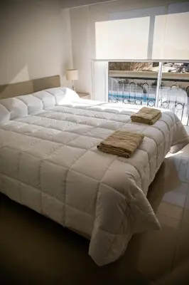 a large white bed with two pillows on top of it at Apart France - Con Gim, Piscina y estacionamiento - Matrimonial in Río Cuarto