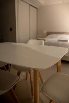 a white table and chairs in a room with beds at Apart France - Con Gim, Piscina y estacionamiento - Matrimonial in Río Cuarto