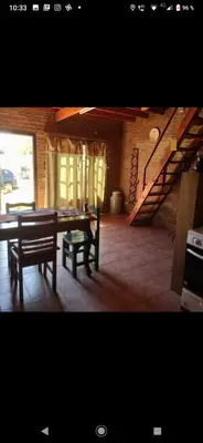 a dining room with a table and a staircase at Lo de chave in Villa Rumipal
