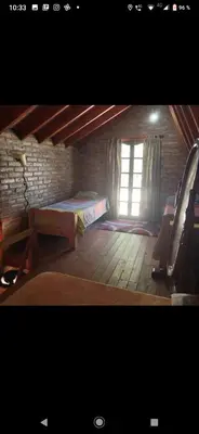 a attic room with a bed and a window at Lo de chave in Villa Rumipal