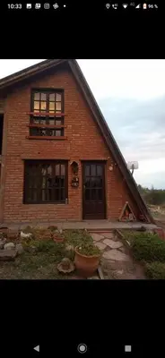 a large brick house with a large window at Lo de chave in Villa Rumipal