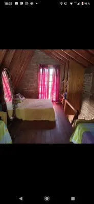 a bedroom with two beds and a window with pink curtains at Lo de chave in Villa Rumipal