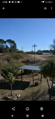a picnic table in a field with two palm trees at Lo de chave in Villa Rumipal