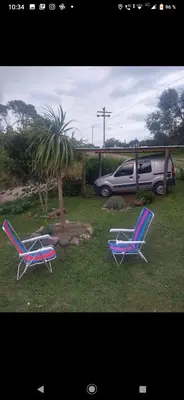 two lawn chairs sitting in the grass next to a car at Lo de chave in Villa Rumipal