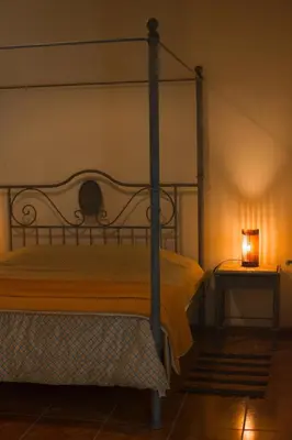 a bed in a room with a lamp on a table at Luna de Alberdi Apart in Cordoba