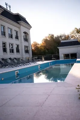 a swimming pool in front of a building at Apart France - Con gim, piscina y estacionamiento in Río Cuarto