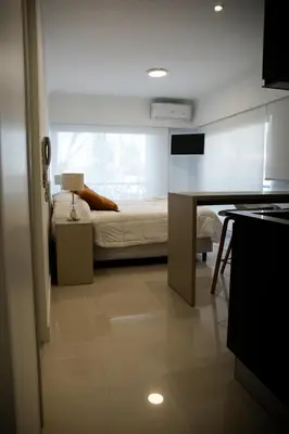 a bedroom with a bed and a desk with a table at Apart France - Con gim, piscina y estacionamiento in Río Cuarto