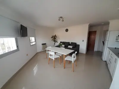 a kitchen and a living room with a table and chairs at ALTOS DE VILLA CABRERA in Cordoba