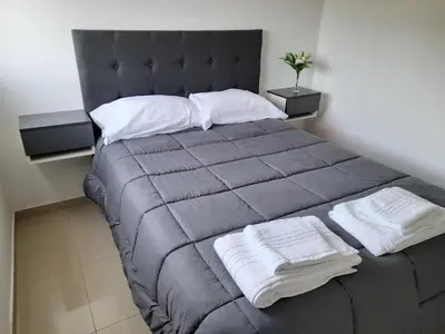 a bedroom with a large bed with towels on it at ALTOS DE VILLA CABRERA in Cordoba