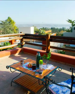 a picnic table on a balcony with a view at Bella Vista Casa con pileta y terraza in Villa Carlos Paz