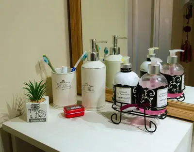 a bathroom counter with four bottles of soap and a mirror at Bella Vista Casa con pileta y terraza in Villa Carlos Paz